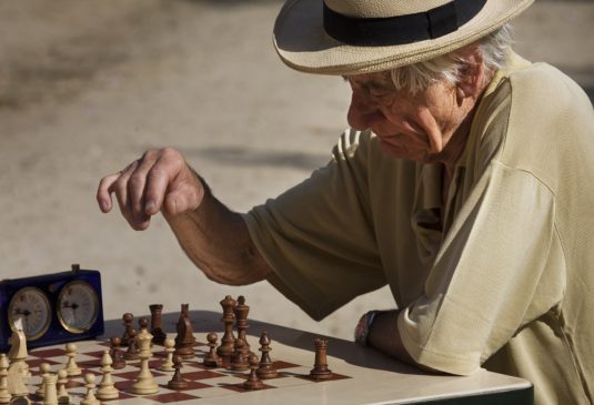 Old retired man playing chess at the Jardins du Luxembourg, Paris
